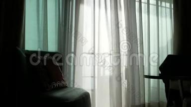 窗上一层透明的帘子，被风轻轻地移动着.. 阳光。 4k